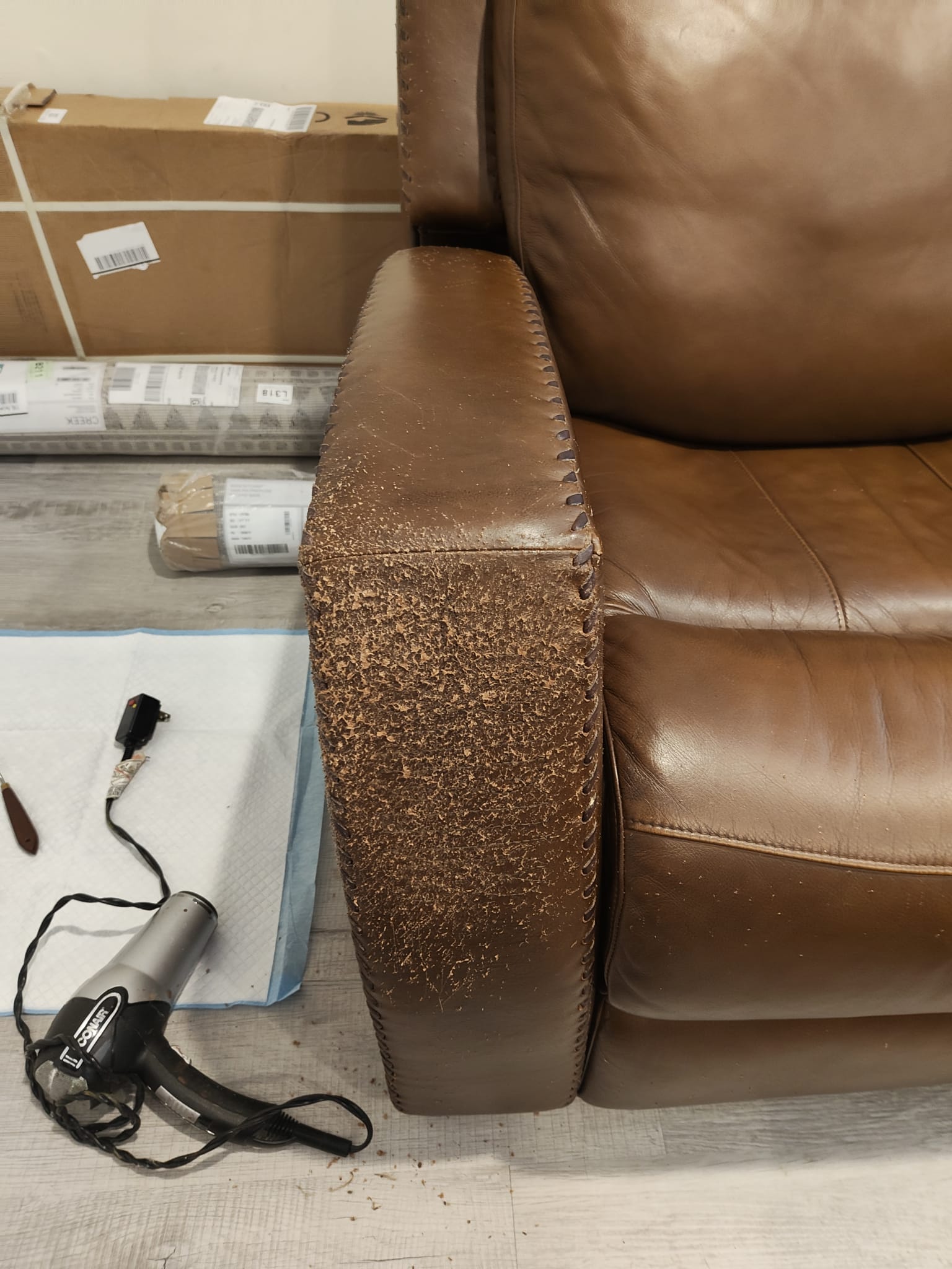 Damaged leather couch before restoration (left side)
